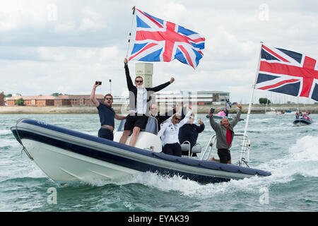 Portsmouth, UK. 25. Juli 2015. Eine kleine Rippe von Gönnern zeigen zwei Anschluß-Markierungsfahne und jubeln auf Ben Ainslie Landrover BAR AC45f als es auf den Solent in Vorbereitung auf das Rennen beginnen heraus leitet. Bildnachweis: MeonStock/Alamy Live-Nachrichten Stockfoto