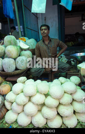 MYSORE, Indien - 4. November 2012: Indische Hersteller sitzt unter den Haufen von frischem Gemüse in der Devaraja-Markt. Stockfoto