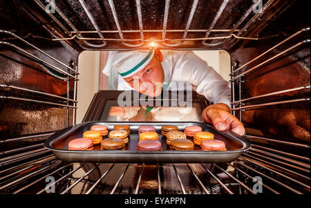 Chefkoch Macarons in den Ofen, Blick aus dem Inneren des Ofens. Kochen in den Ofen. Stockfoto