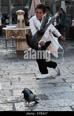 Jerusalem, Israel. 26. Juli 2015. Ein kleiner Junge jagt Tauben an der Klagemauer als Tausende von Gläubigen Juden beten auf Tisha B'Av, 9. des hebräischen Monats von Av, zum Gedenken an die Zerstörung des ersten Tempels (babylonischen König Nebukadnezar II, 587 v. Chr.) und des zweiten Tempels (70 CE, römische Legionen unter Titus). Bildnachweis: Nir Alon/Alamy Live-Nachrichten Stockfoto