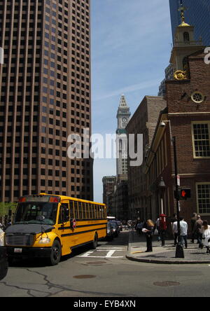 Schulbus am Old State House, Boston, Massachusetts im Vordergrund mit einem Exchange Place und dem Customs House im Hintergrund. Stockfoto