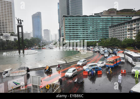 Straßenverkehr am Bundaran HI (Hotel Indonesia Roundabout) an einem regnerischen Tag im Zentrum von Jakarta, Jakarta, Indonesien. Stockfoto