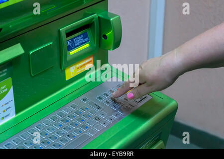 Die Hand des Menschen (Frau) gewinnt PIN-Code auf der Tastatur des ATM-Terminals Stockfoto