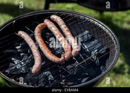 heißen Grill Würstchen grillen am Gitter über Holzkohle Stockfoto