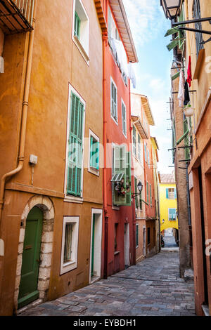 Farbenfrohe Gebäude mit hellen Fenster Fensterläden entlang der Straße mit Kopfsteinpflaster in der mittelalterlichen Altstadt Villefranche-Sur-Mer auf Französisch Riv Stockfoto