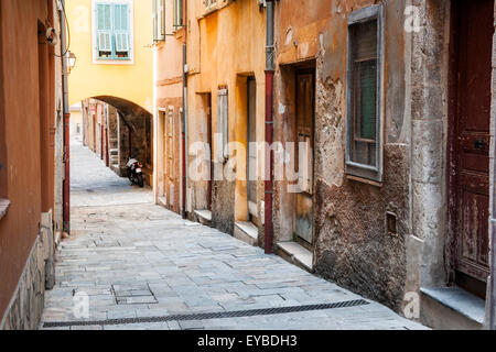 Alte Häuser entlang der schmalen Straße mit Kopfsteinpflaster in der mittelalterlichen Stadt Villefranche-Sur-Mer an der Côte d ' Azur, Frankreich. Stockfoto