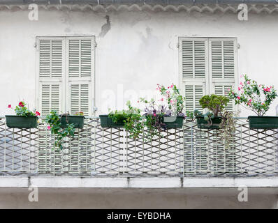 Französischer Balkon mit verschlossenen Türen und Blumenkästen auf alten Haus in Villefranche-Sur-Mer, Frankreich. Stockfoto