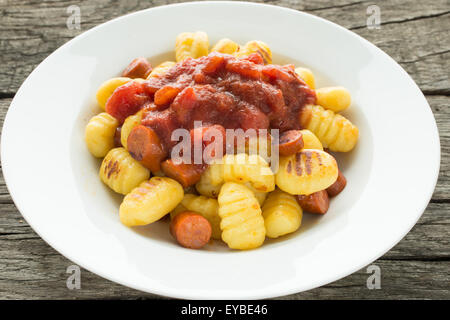 Gebratene Gnocchi mit Tomatensauce und Würstchen Stockfoto