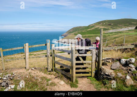 Zwei Wanderer zu Fuß durch ein küssen Tor auf Wales Meer Weg von Porth Llanllawen Lleyn Halbinsel / Pen Llyn Gwynedd Wales UK Stockfoto