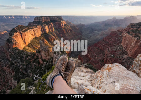 Person sitzen zeigen Füße nur mit Wanderschuhen auf Grand Canyon National Park, North Rim, Arizona Stockfoto