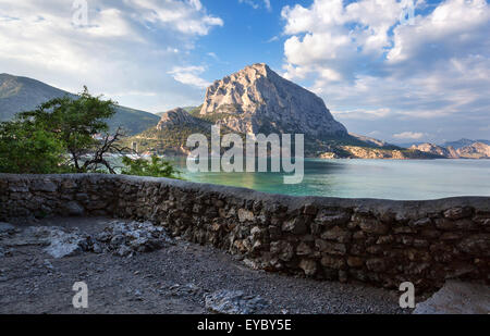 Schönen Sommer Sonnenuntergang am Meer mit Bergen und Steinen auf der Krim