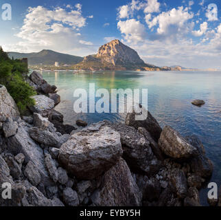 Schönen Sommer Sonnenuntergang am Meer mit Bergen und Steinen auf der Krim Stockfoto