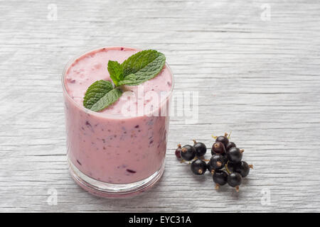 Frische Milch, Johannisbeere, Himbeere und rote Johannisbeere Getränke auf Wodeen Tisch, verschiedene Protein-Cocktails mit frischen Früchten Stockfoto