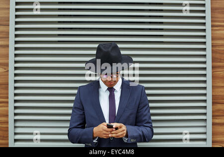 Elegante Geschäftsmann im Anzug, Hut und Brille mit Handy von jalousie Stockfoto