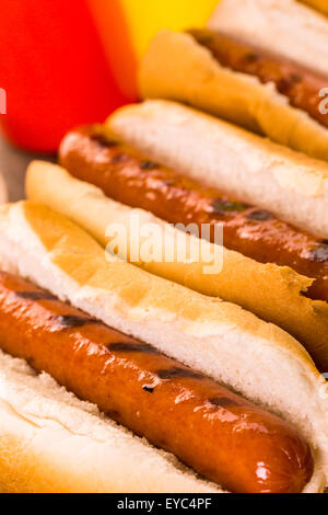 Gegrillte Würstchen auf eine weiße Hot-Dog-Brötchen mit Pommes Frites und gebackene Bohnen auf der Seite. Stockfoto