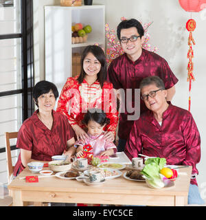 Frühling Jahreszeiten Chinese New Year Reunion Abendessen. Gerne asiatische chinesische Multi-Generationen-Familie mit roten Cheongsam unter Gruppe pho Stockfoto