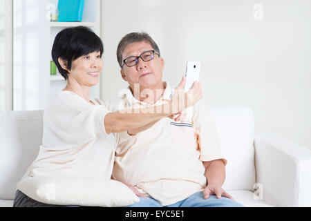 Moderne Technik, Alter und Mensch Konzept. Asiatische älteres paar Selfie, mit Smartphone, selbst fotografieren. Familien leben Leben Stockfoto