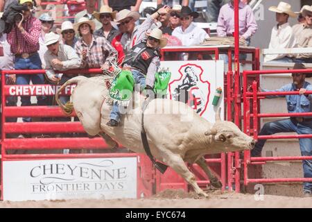 Cheyenne, Wyoming, USA. 26. Juli 2015. Bull Rider Aaron Pass hängt beim Bull Riding Finale bei den Cheyenne Frontier Days Rodeo in Frontier Park Arena 26. Juli 2015 in Cheyenne, Wyoming. Pass fuhr fort, um die Bull Riding Meisterschaft zu gewinnen. Stockfoto