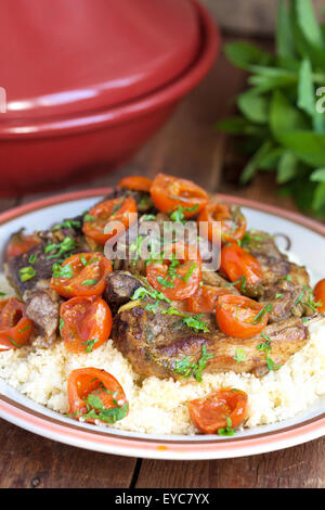 Marokkanische Tagine mit Lamm, Tomaten und Couscous auf einem Holztisch. Selektiven Fokus. Stockfoto