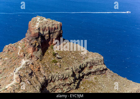 Skaros Felsenvorsprung in Imerovigli mit Wanderweg und Boot auf der Ägäis. Santorini, Kykladen, Griechenland. Stockfoto