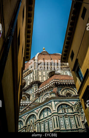 Die Kuppel von Filippo Brunelleschi auf der Kathedrale von Florenz hat einen Blick zwischen den Gebäuden der Stadt Florenz, Italien. Stockfoto