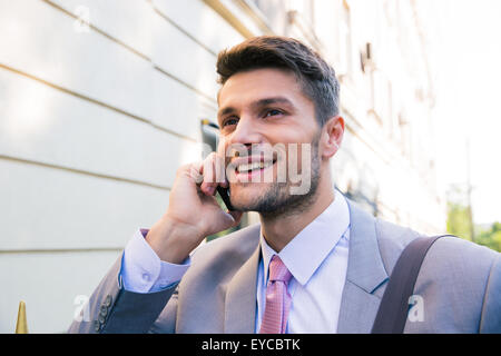Porträt eines lächelnden Geschäftsmann im freien telefonieren Stockfoto