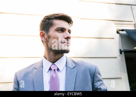 Porträt eines schönen Geschäftsmann im Freien stehen und wegsehen Stockfoto