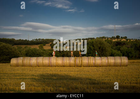 In einem Feld nördlich von Barcelon, Spanien, eine Gruppe von Kindern spielen auf Heuballen. Stockfoto