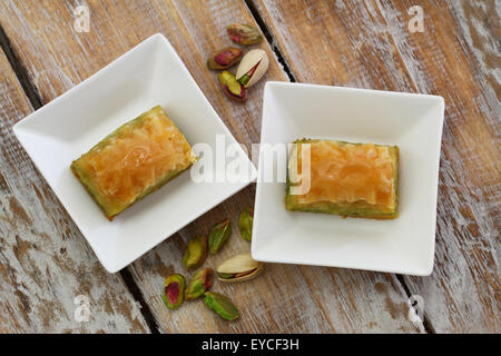 Pistazien Baklava in weißen Schalen auf rustikalen Holzoberfläche Stockfoto