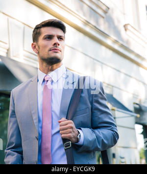 Porträt eines zuversichtlich jungen Geschäftsmann walking im Freien in der Stadt Stockfoto