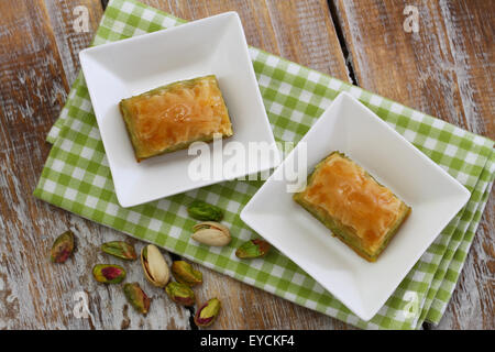 Pistazien Baklava in weißen Schalen auf rustikalen Holzoberfläche Stockfoto