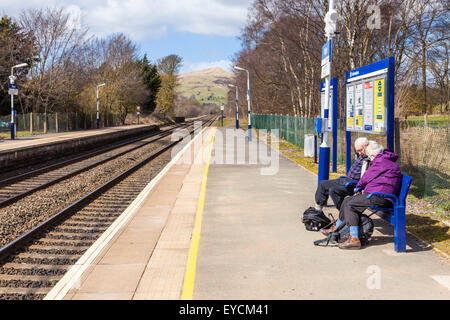 Die Menschen warten auf einen Zug auf der Plattform in der Hoffnung Bahnhof in der Landschaft. Derbyshire Peak District National Park, England, Großbritannien Stockfoto