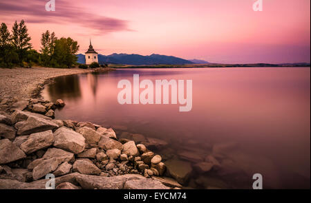 Sonnenuntergang über einer kleinen Kirche in Liptov, Slowakei. Langzeitbelichtung geschossen. Stockfoto