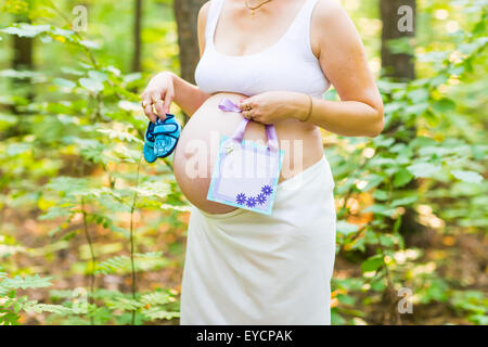 Schwangere Frau mit einem Baby Babyschuhe Stockfoto