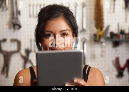 Weibliche Mechaniker in der Werkstatt, mit digital-Tablette Stockfoto