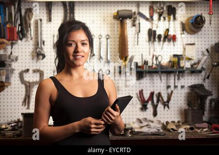 Weibliche Mechaniker in der Werkstatt, mit digital-Tablette Stockfoto