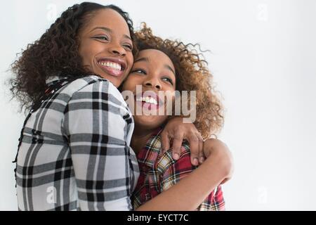 Studio-Porträt von zwei jungen Freundinnen umarmen Stockfoto