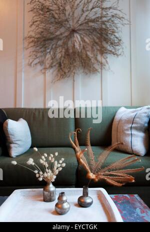 Wohnzimmer mit getrockneten Blumenarrangements an Wand und Couchtisch Stockfoto