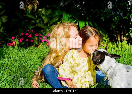 Hund leckt Mädchen Gesicht im Garten Stockfoto