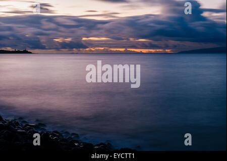 Bewegungsunschärfe von Gewitterwolken über Meer in der Abenddämmerung, Maui, Hawaii Stockfoto