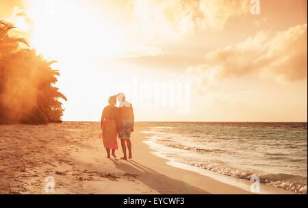 Älteres Paar am Strand bei Sonnenuntergang, Malediven Stockfoto