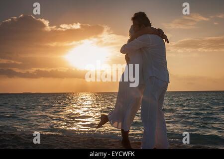 Älteres paar umarmt am Strand, Malediven Stockfoto