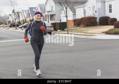 Ältere Frau, Joggen in der Straße Stockfoto
