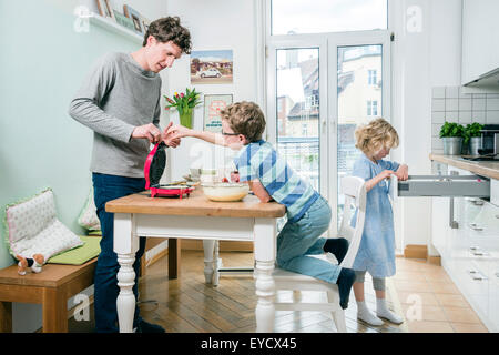 Vater und Kinder Backen von Waffeln in Küche Stockfoto