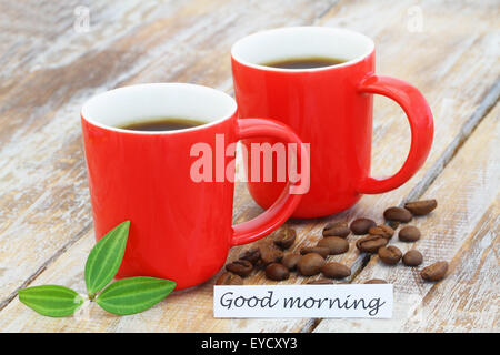 Guten Morgen Karte mit zwei Tassen Kaffee und Kaffeebohnen verstreut auf rustikalen Holzoberfläche Stockfoto
