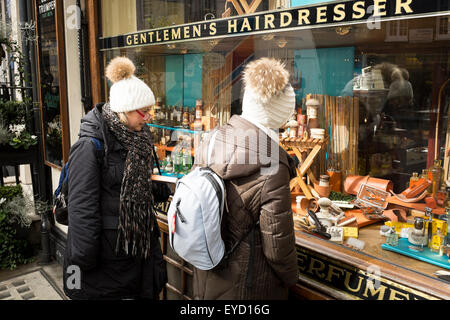 Zwei weibliche Trouist Blick in die Schaufenster von G F Trumper, einem traditionellen Barbershop in Mayfair, London, UK Stockfoto