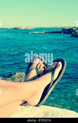 Nahaufnahme der Füße eines Mannes mit Flip-flops, entspannen am Meer im Sommer, gefiltert ist Stockfoto