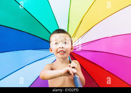 Gesicht Porträt des Lächelns fröhlichen jungen ein Spaß und drehen Regenschirm mit leuchtend bunten Muster. Stockfoto