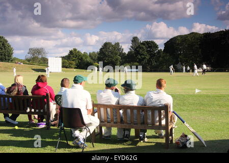 Kricketspieler sehen Sie ihr Team, die Verknüpfungen in einem Match in einem Yorkshire-Dorf in der Nähe von Rotherham, England UK konkurrieren Stockfoto