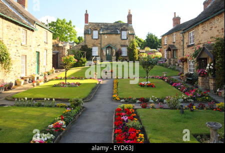 traditionelle Stein gebauten Hütten umgeben unberührte Gärten in einem englischen Dorf, England UK - Sommer 2015 Stockfoto